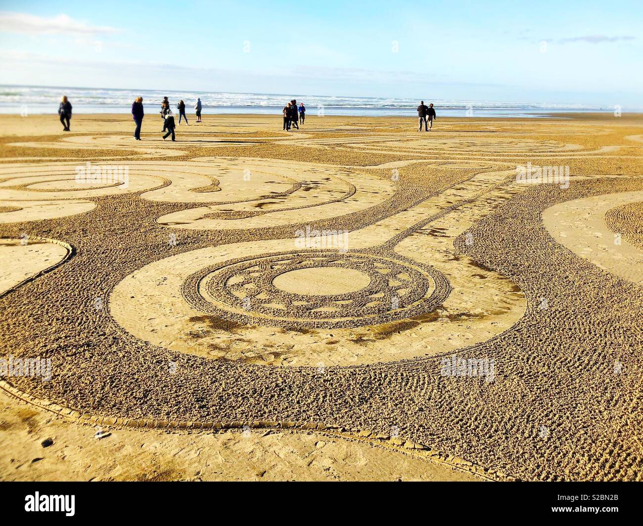 People walking a sand labyrinth at Heceta beach in Florence, Oregon, USA. Stock Photo