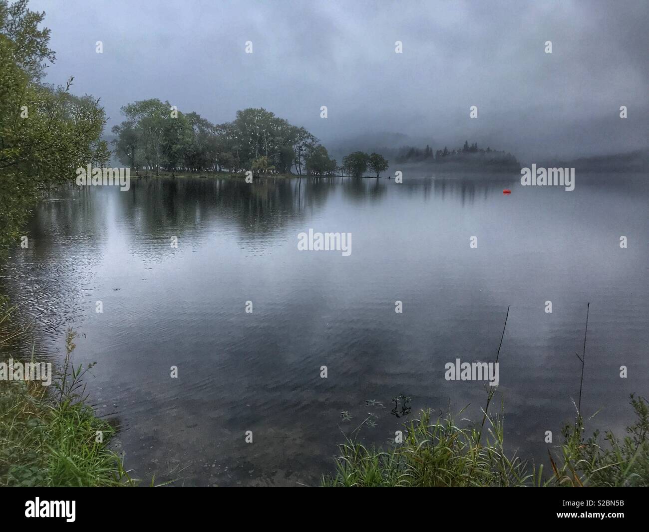 Morning mist on an overcast day, on a loch, Loch Lomond and The Trossachs National Park, Perthshire, Scotland - Smartphone Captured Stock Image
