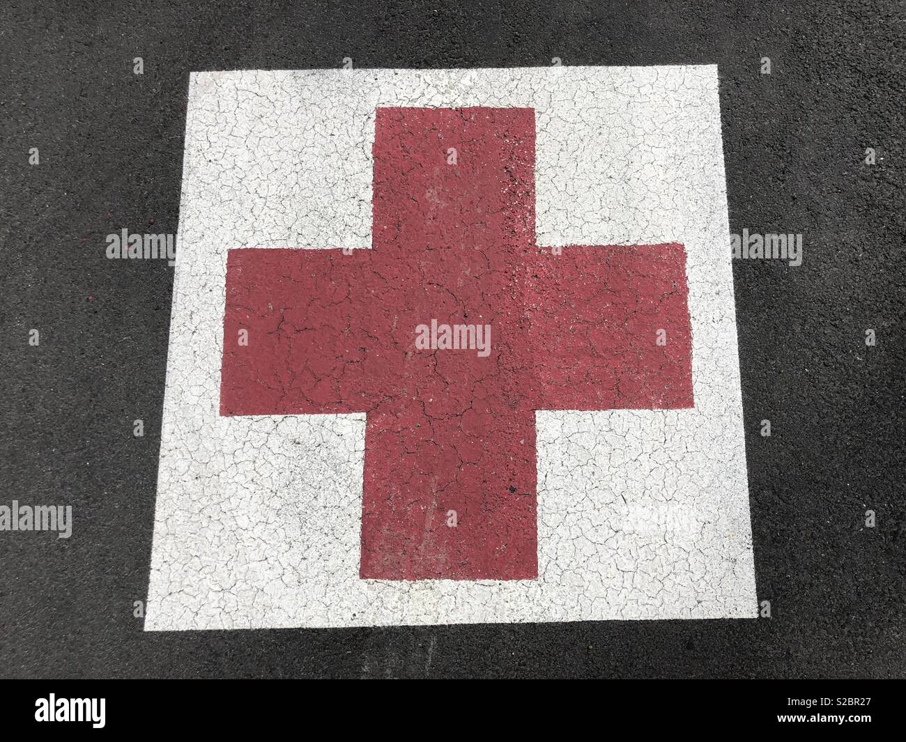 Red cross painted on asphalt - Smartphone Captured Stock Image