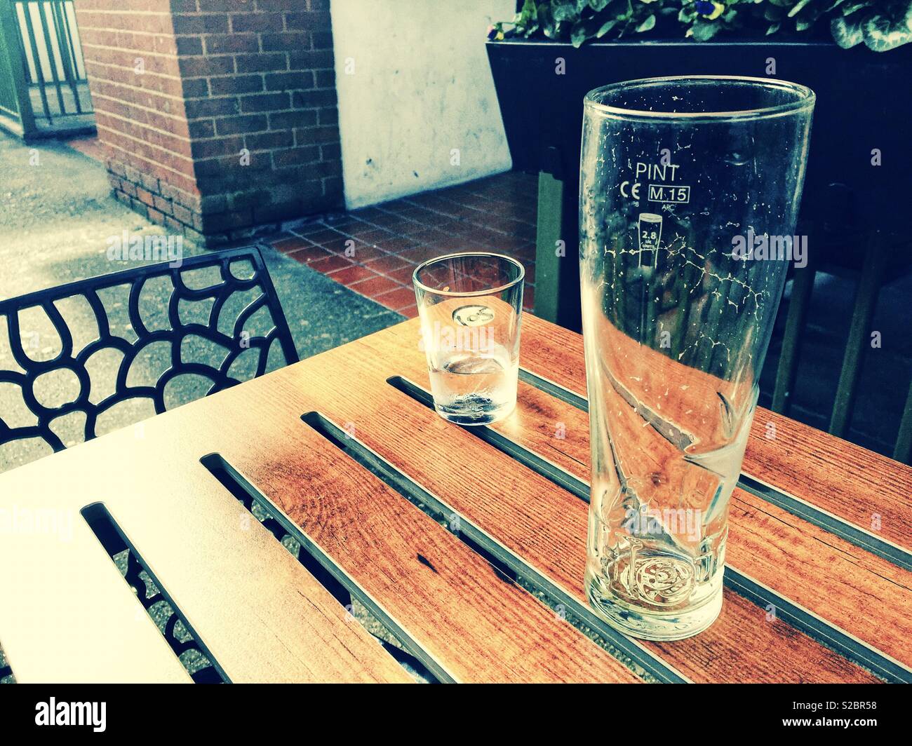 Empty glasses on a table in a pub beer garden. - Smartphone Captured Stock Image