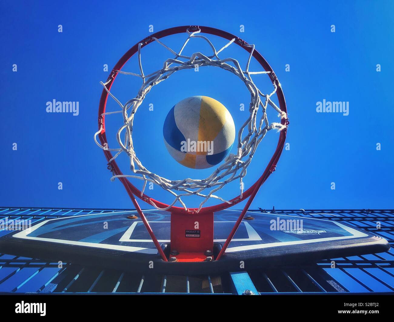 Basketball dropping through a hoop from underneath Stock Photo Alamy