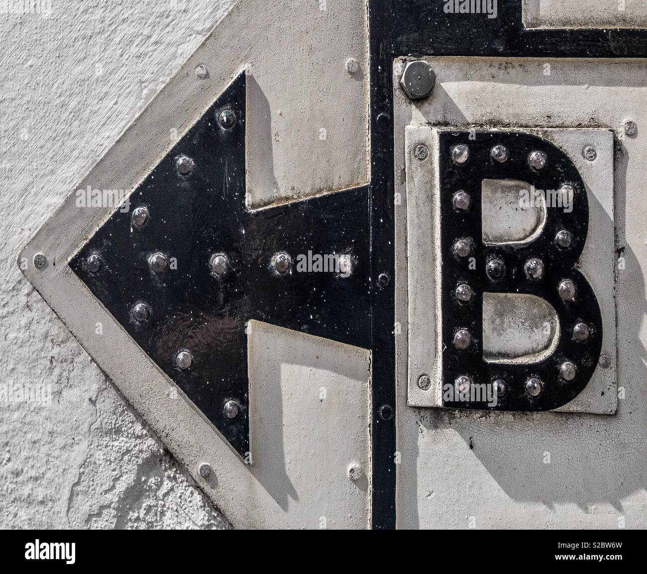 Letter B and arrow sign on wall - Smartphone Captured Stock Image