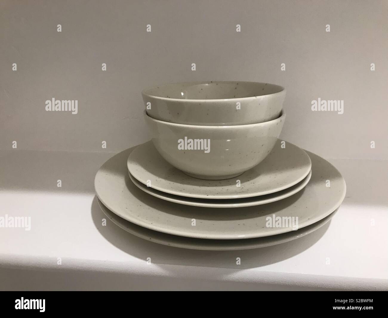 White dishes sitting on the shelf bowls and plates Stock Photo Alamy