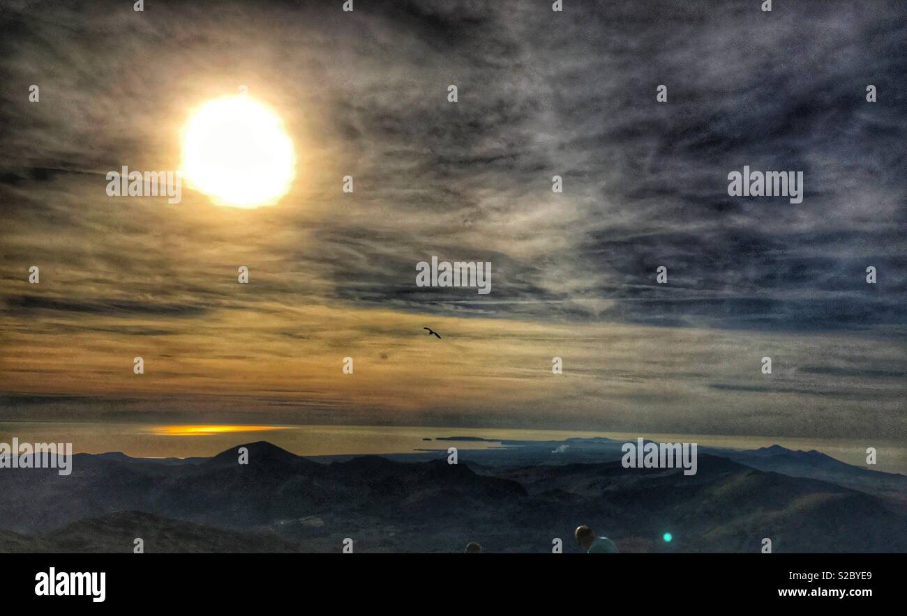 Setting sun shining on the sea, taken from the summit of mount Snowdon Stock Photo