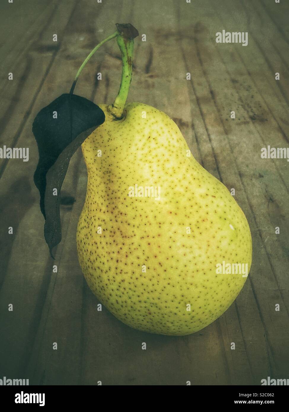 Ripe green pear with rad on wooden table - Smartphone Captured Stock Image