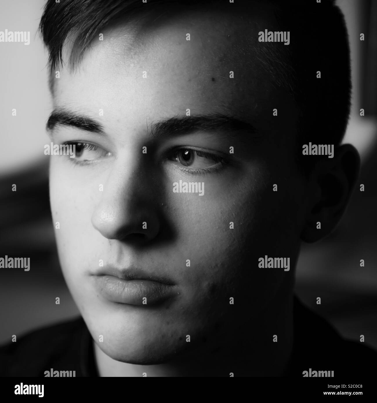 A portrait study in black and white , handsome young man looking away from camera - Smartphone Captured Stock Image