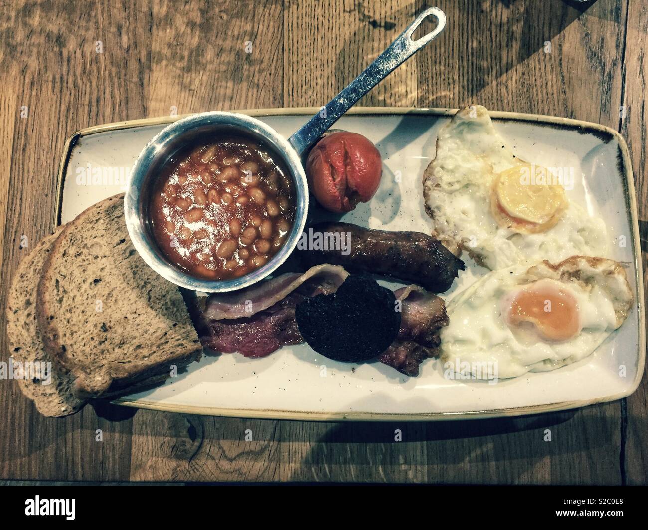 All day full English breakfast meal on a wooden table top. - Smartphone Captured Stock Image
