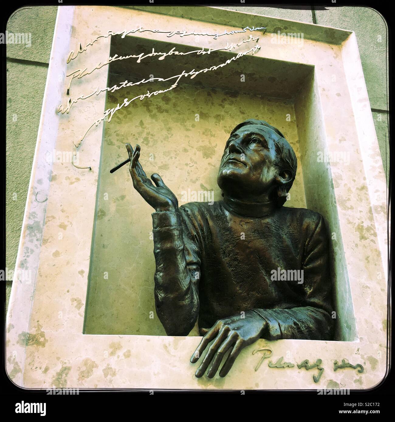 Sculpture of a man smoking out of a window. Budapest, Hungary. Stock Photo