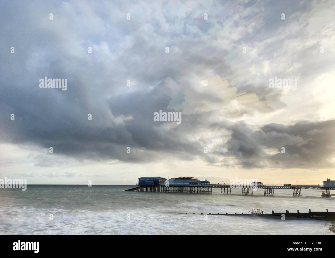 Cromer Pier under a moody cloud at sunrise. - Smartphone Captured Stock Image