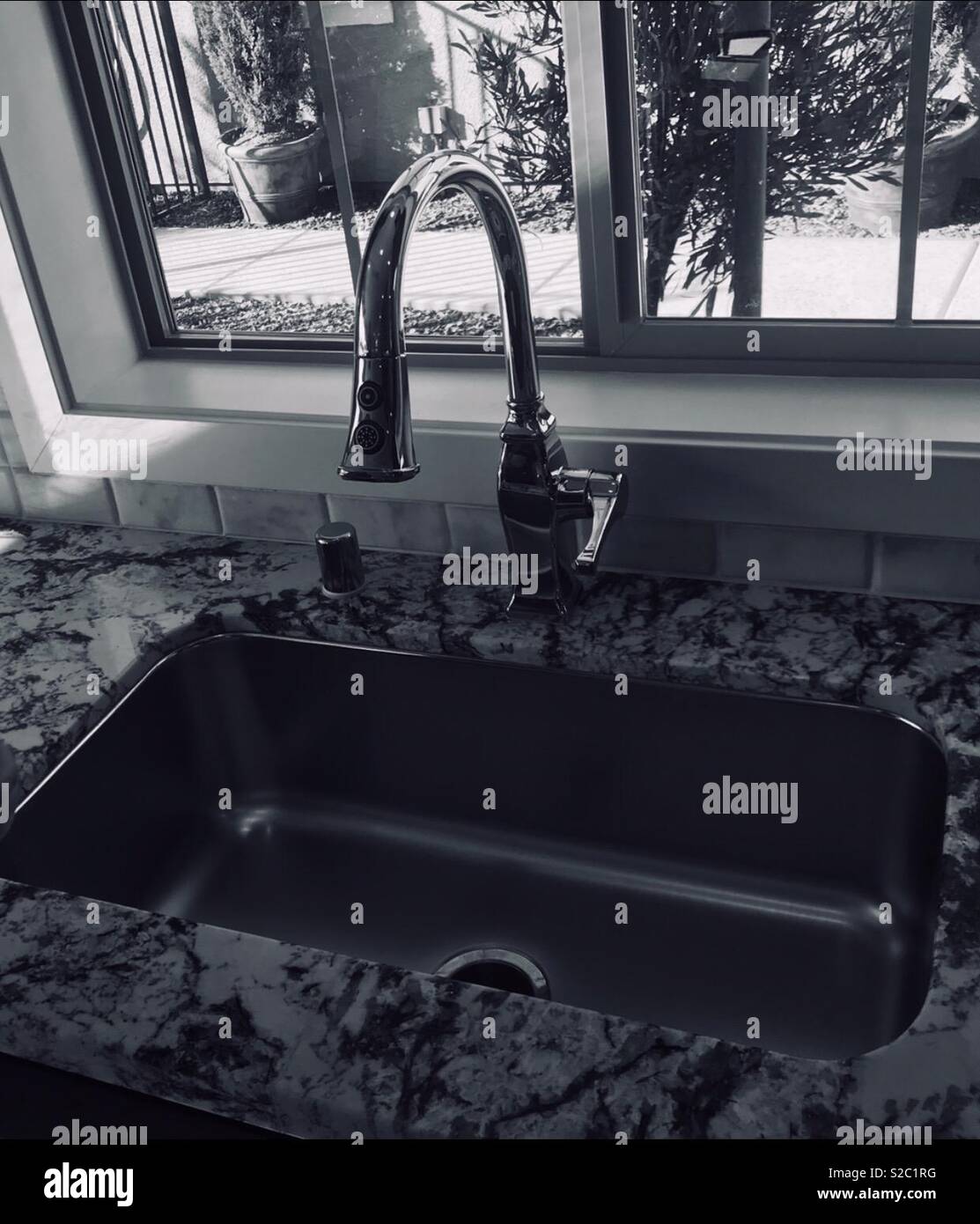 Monochrome Photo Of A Kitchen Sink And Faucet And Granite