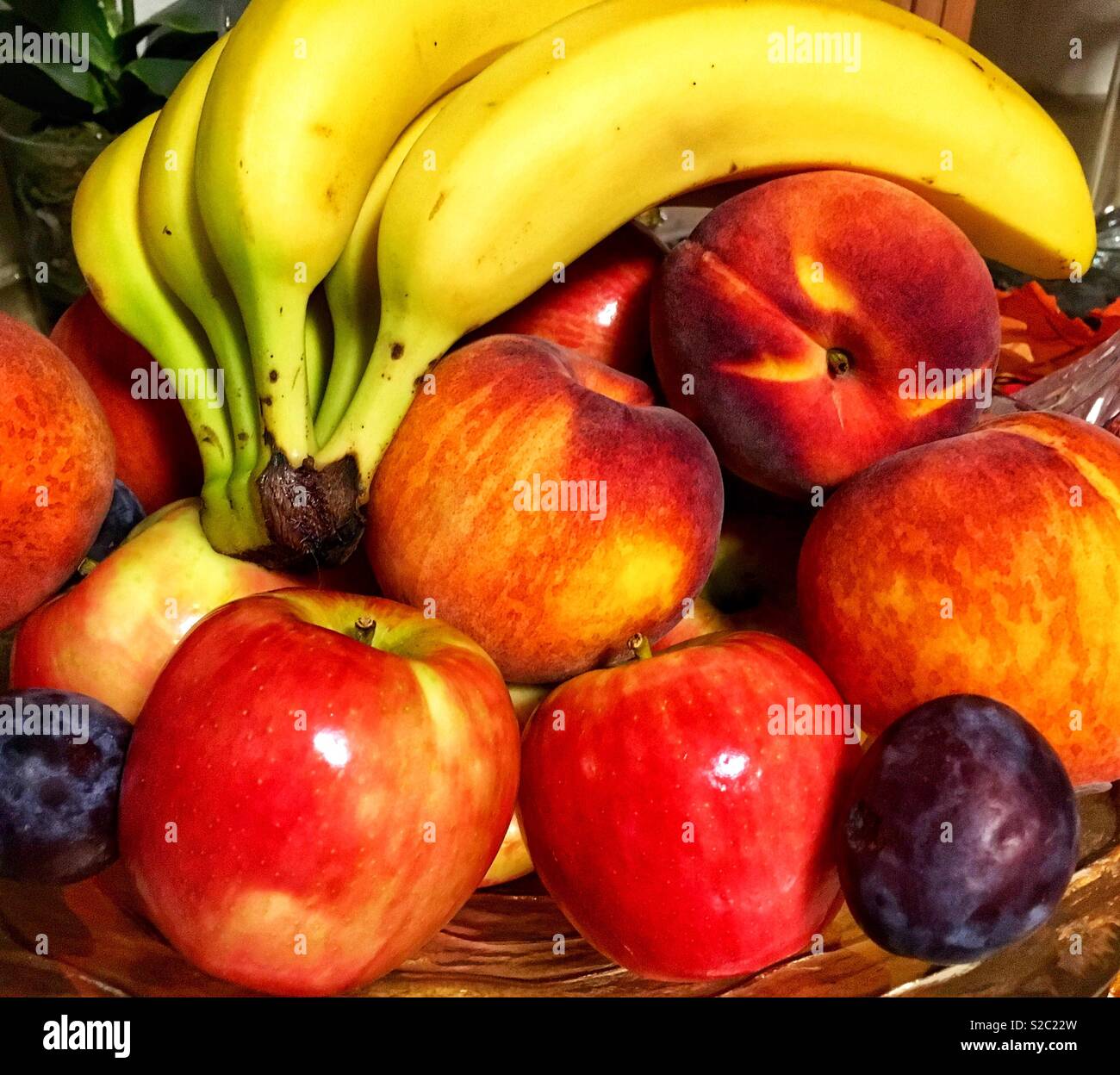 https://c8.alamy.com/comp/S2C22W/fruit-in-a-glass-bowl-including-a-bunch-of-bananas-red-and-green-mcintosh-apples-purple-plums-and-nectarines-S2C22W.jpg