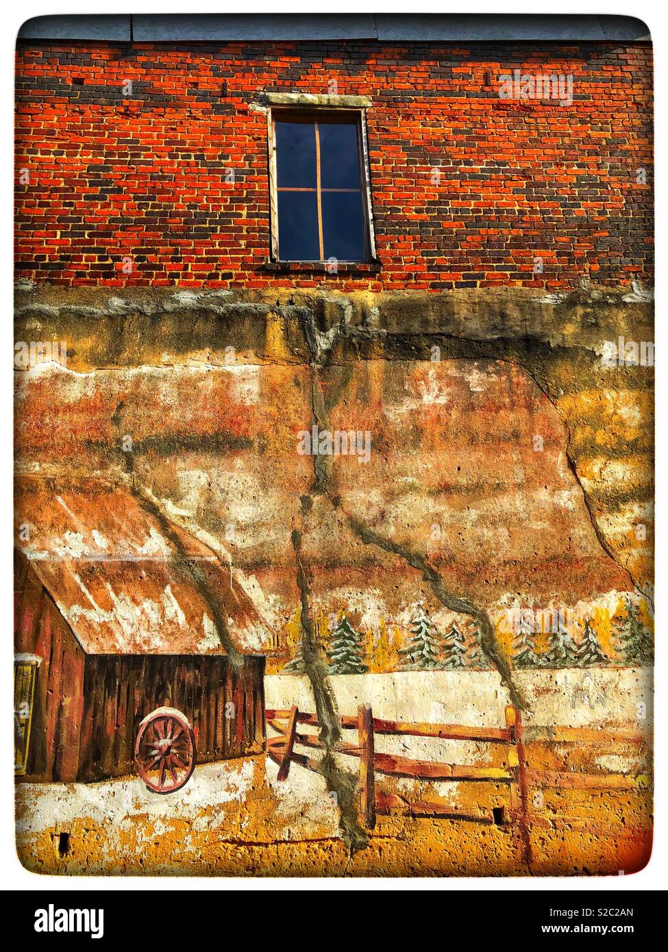 Painting the side of an old brick building Stock Photo