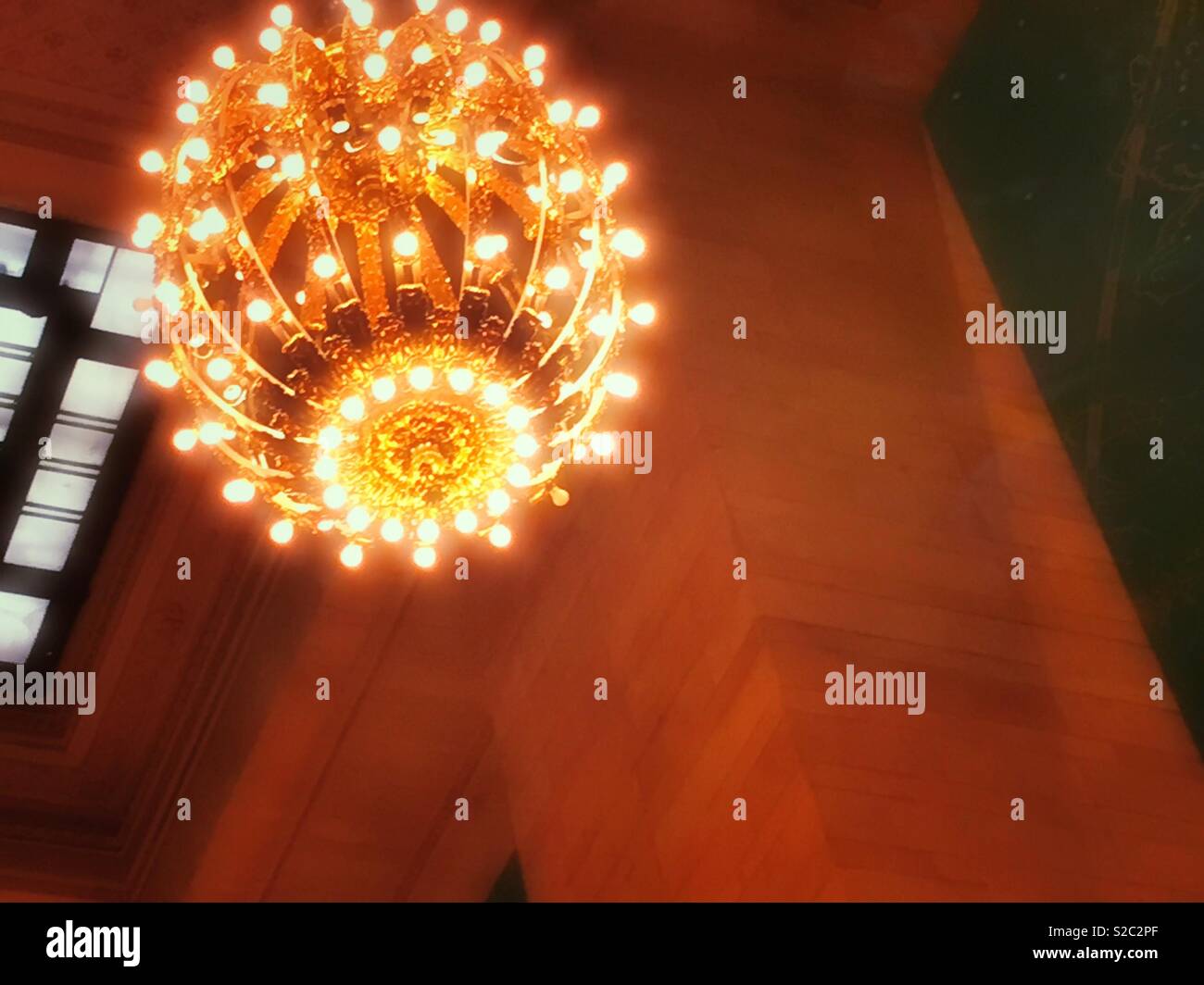 Huge lighting chandelier hanging from the ceiling of Grand Central terminal, NYC, USA Stock