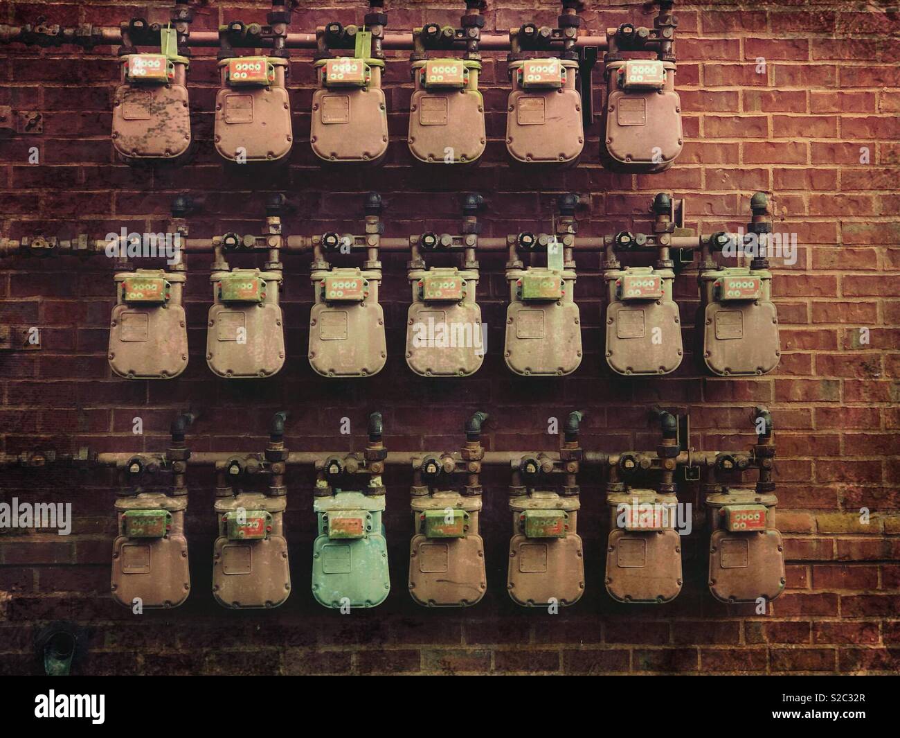 Many meters in rows mounted on a red brick wall - Smartphone Captured Stock Image