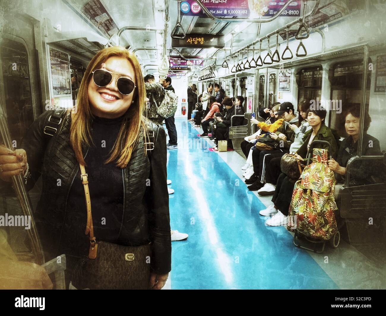 Passengers on a train on the Seoul underground railway system. - Smartphone Captured Stock Image