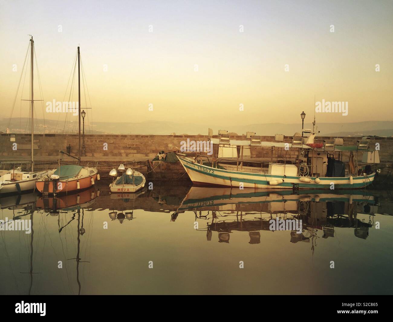 Fishing boats moored in old port of Muggia, Italy - Smartphone Captured Stock Image