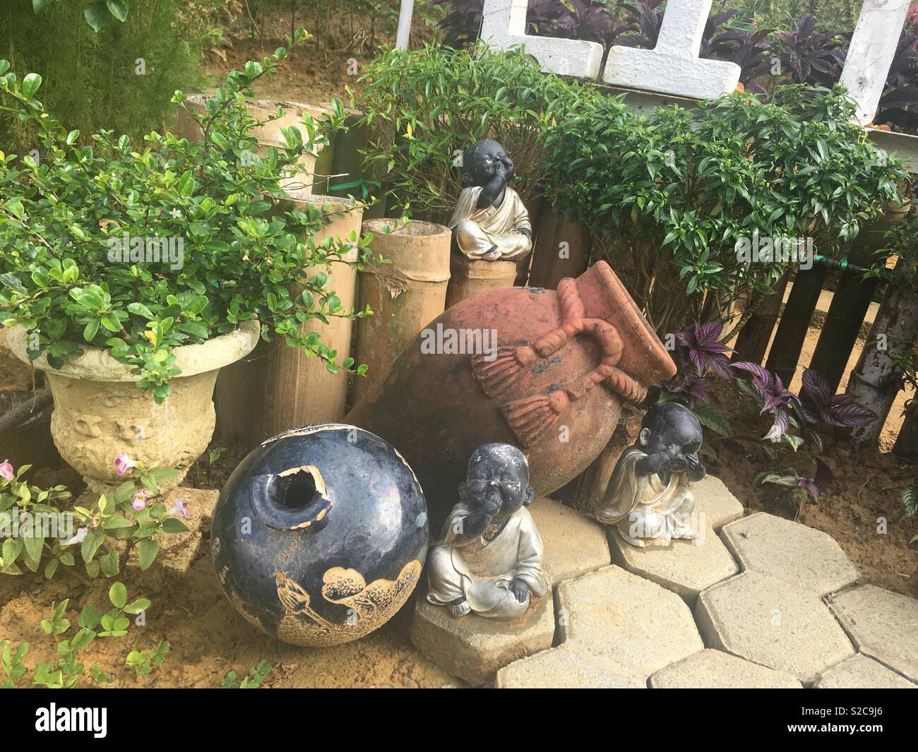 Faded little buddha statues over some overturned jars - Smartphone Captured Stock Image