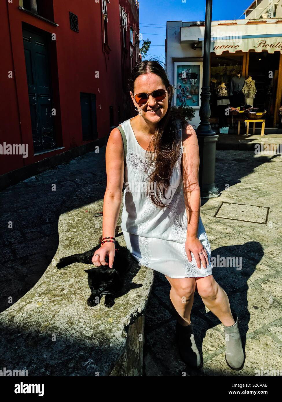 Girl stroking cat on Isle of Capri, Italy - Smartphone Captured Stock Image