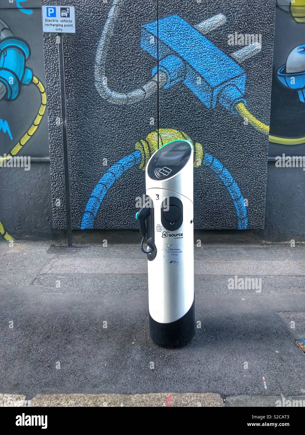 Electric car charger on pavement in shoreditch, east London, Britain. In front of street art mural. No people. Stock Photo