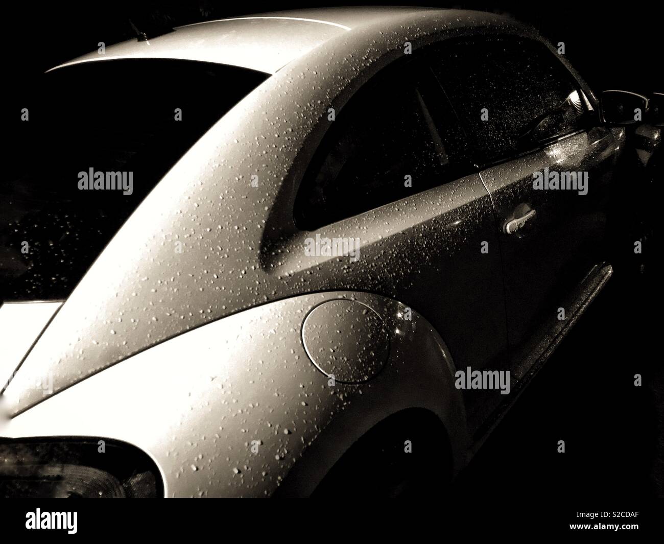 Moody sepia toned image of a Volkswagen Beetle covered in rain droplets - Smartphone Captured Stock Image