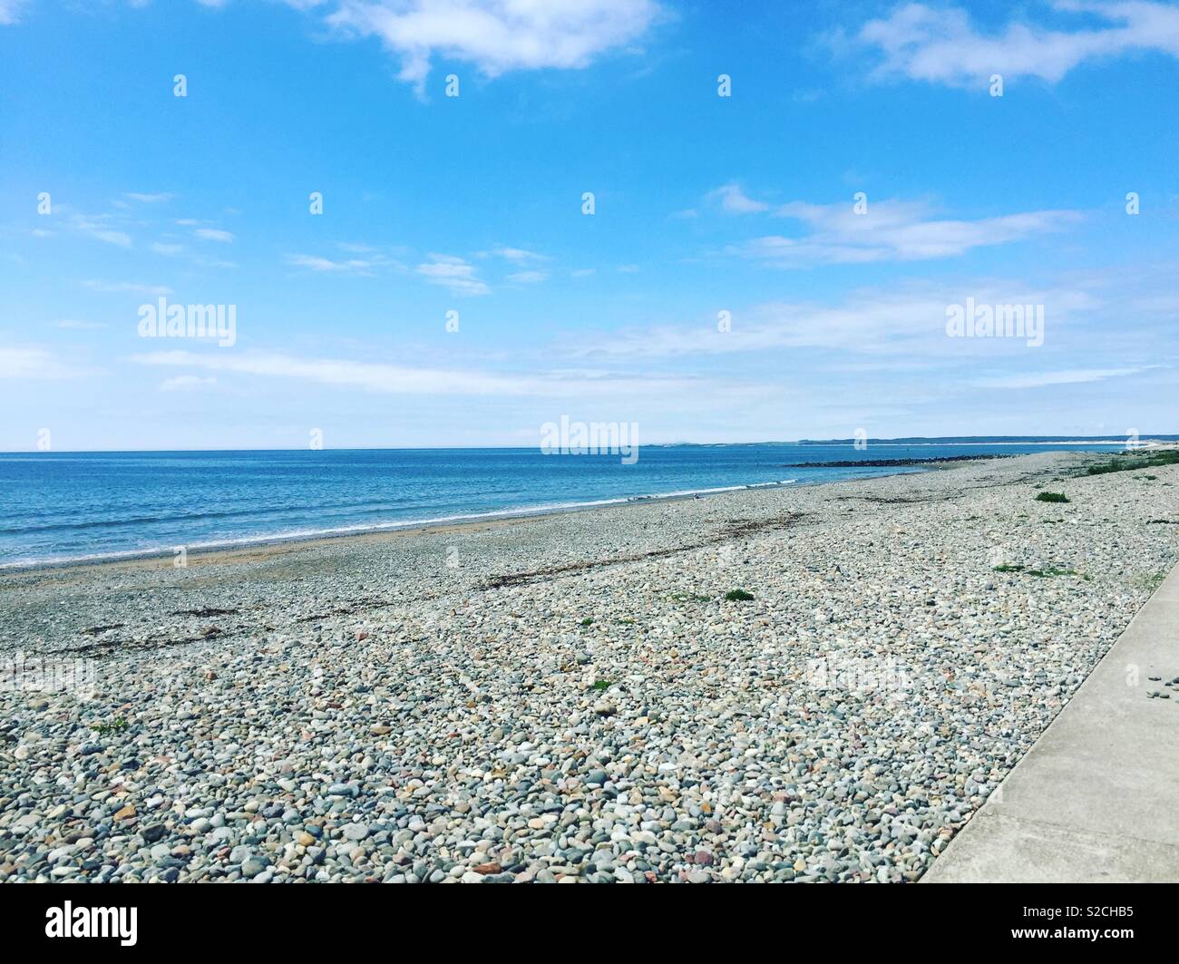 Beautiful blue sky and pebble beach, by the seaside l, relaxing getaway Stock Photo