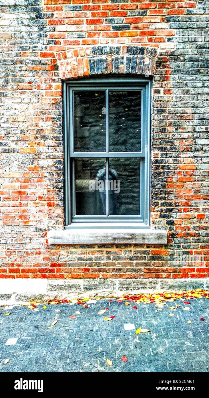 Window in old brick wall with faceless man - Smartphone Captured Stock Image