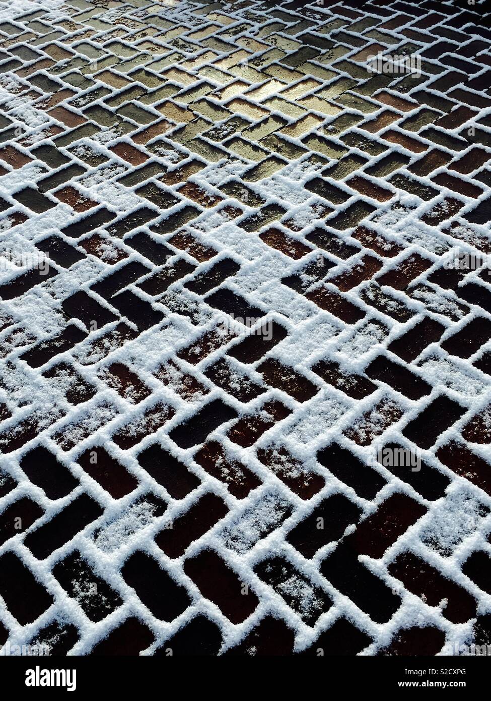 Brick driveway covered with melting snow Stock Photo Alamy