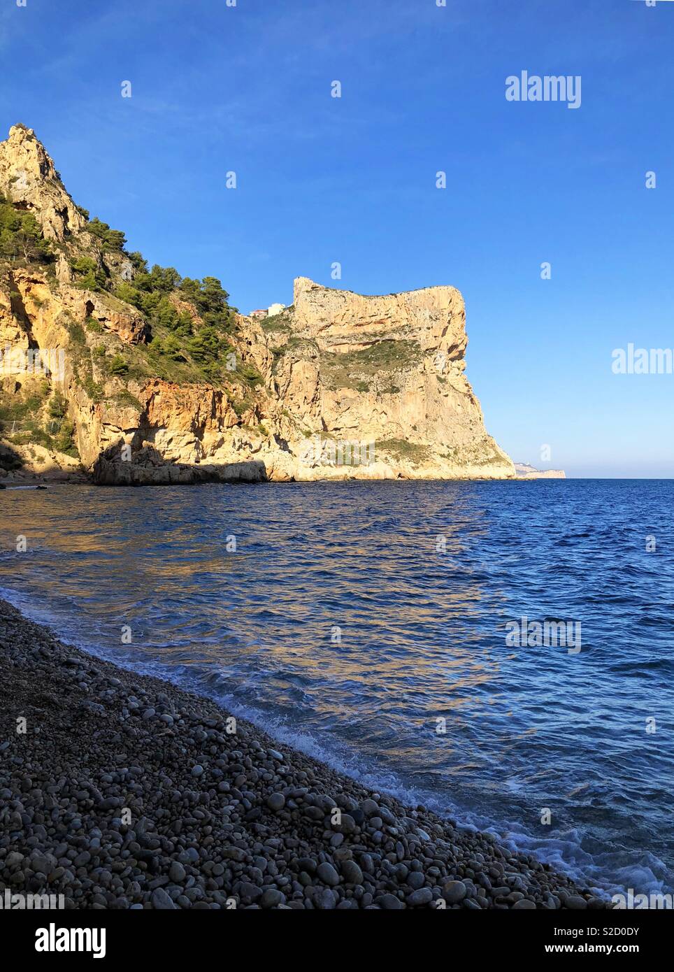 Cala del Moraig and dramatic sea cliffs in late afternoon sunlight, near Benitachell on the Costa Blanca, Spain - Smartphone Captured Stock Image
