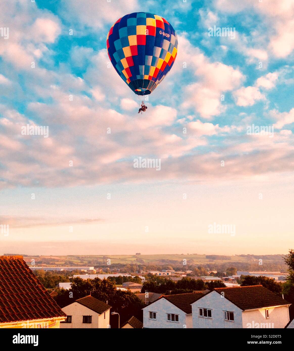 Balloonist over houses!! Stock Photo
