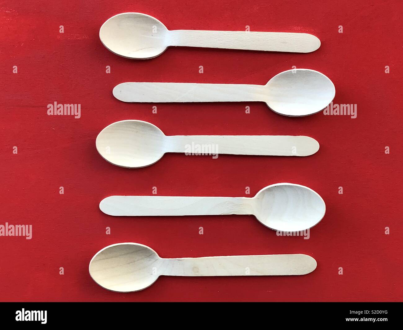 Wooden spoons over red paintedwooden board - Smartphone Captured Stock Image