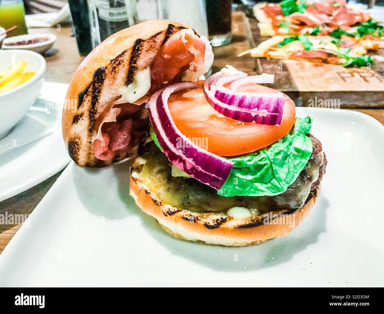 Cheeseburger on a white plate in a restaurant - Smartphone Captured Stock Image