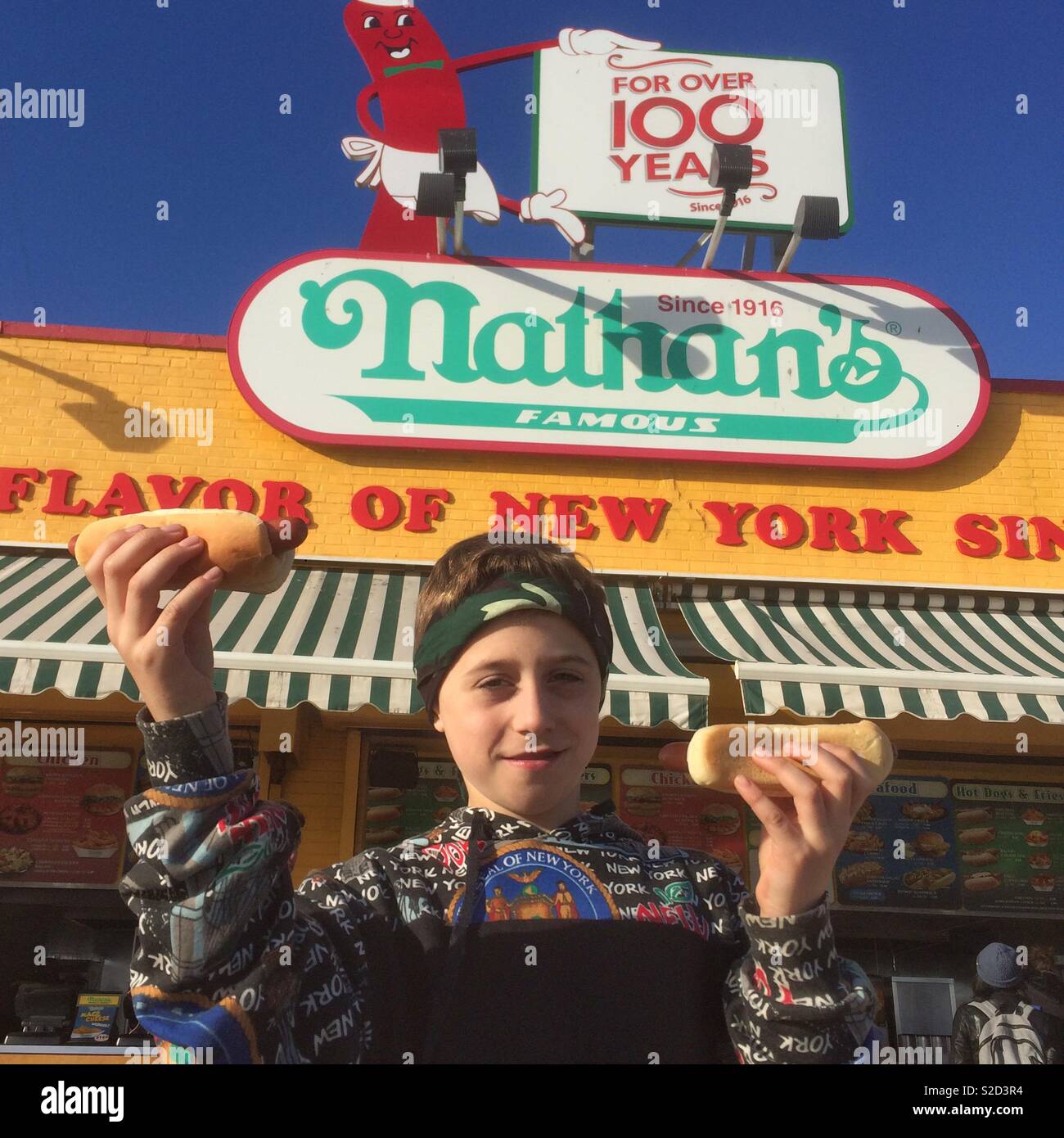 Nine year old boy with hot dogs, Nathan’s Coney Island, Brooklyn, New York, United States of America. Stock Photo