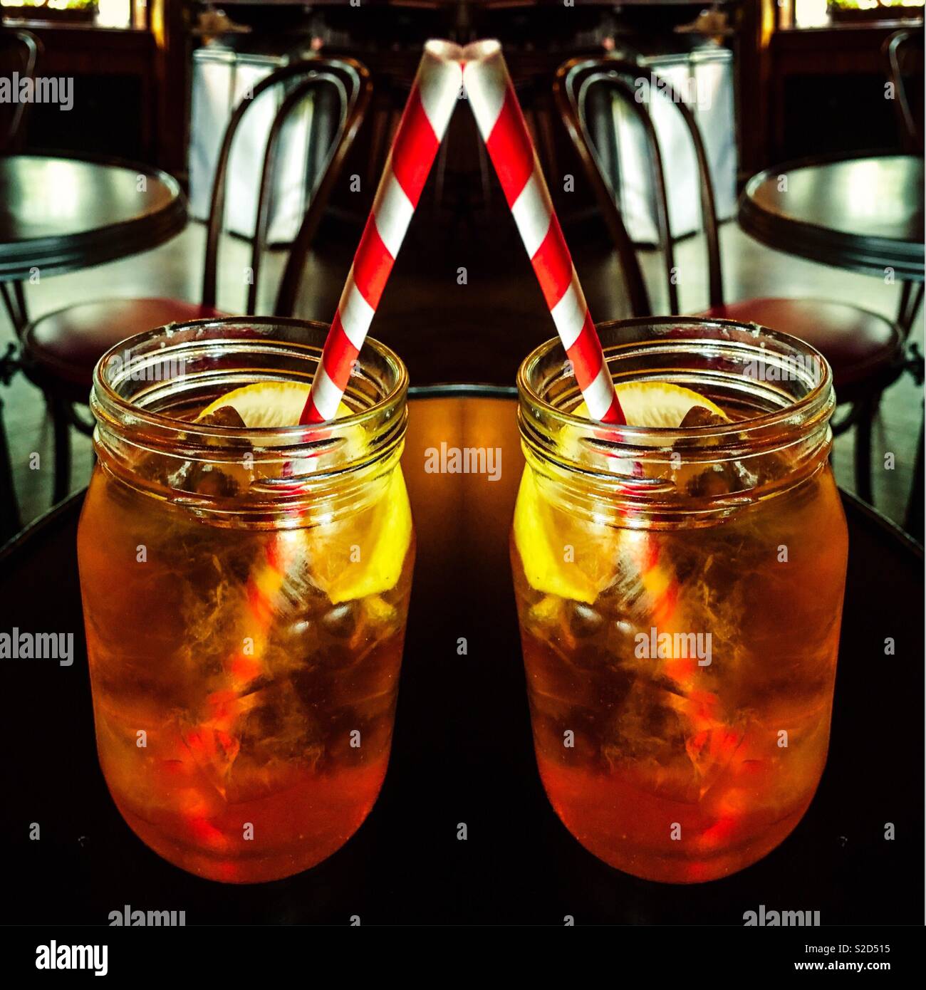 Double exposure iced tea in mason jar glasses with eco friendly paper straws. Europe announced a ban on some plastics including straws.These brightly colored paper straws are fun an good for the earth - Smartphone Captured Stock Image