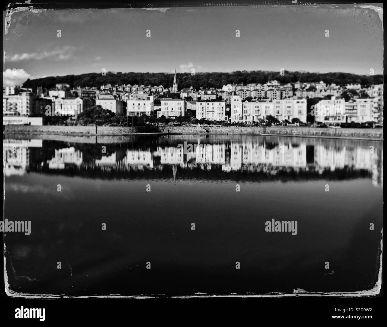A faux tintype photograph of buildings on the hillside reflected in the Marine Lake in Weston-super-Mare, UK Stock Photo