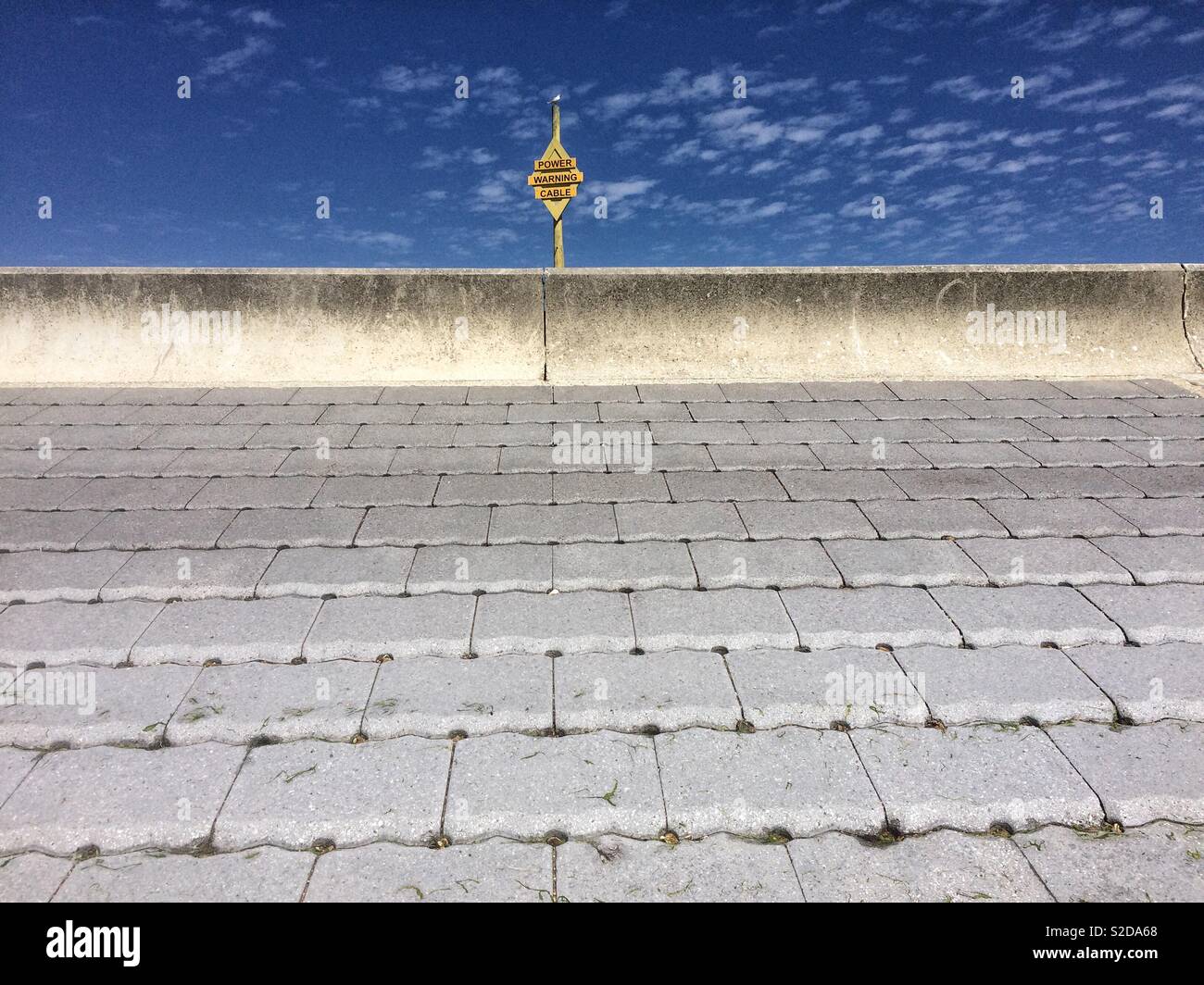 Close view of concrete slabs and electrical warning signal near seaside,Leper’s Beach,Hampshire. - Smartphone Captured Stock Image