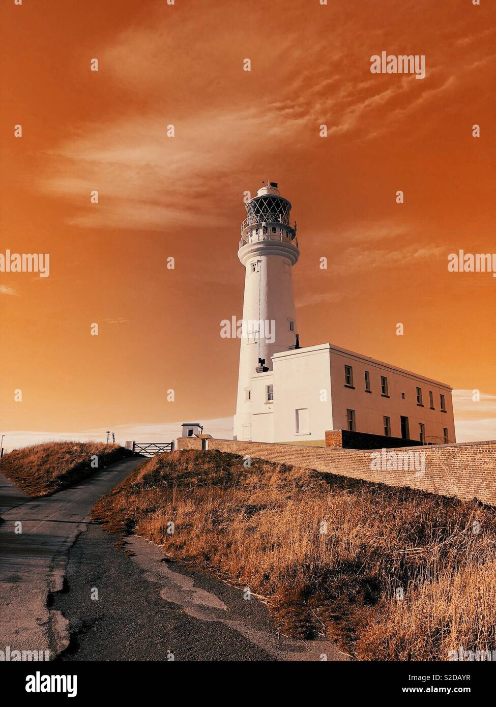 White lighthouse with orange sky - Smartphone Captured Stock Image