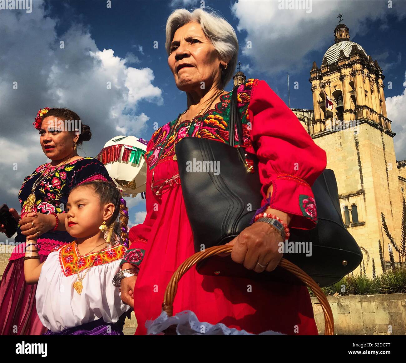 Three generations of Oaxacan women walk in front of the Church of Santo Domingo in Oaxaca, Mexico Stock Photo
