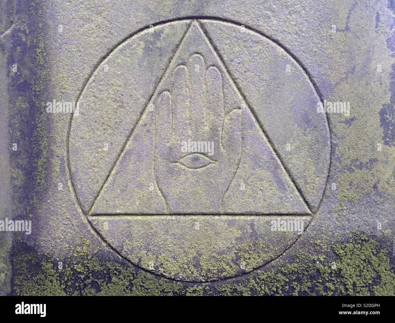 Mysterious geometric grave stone in historic graveyard - Masonic Victorian religious symbolism with hand and eye Stock Photo