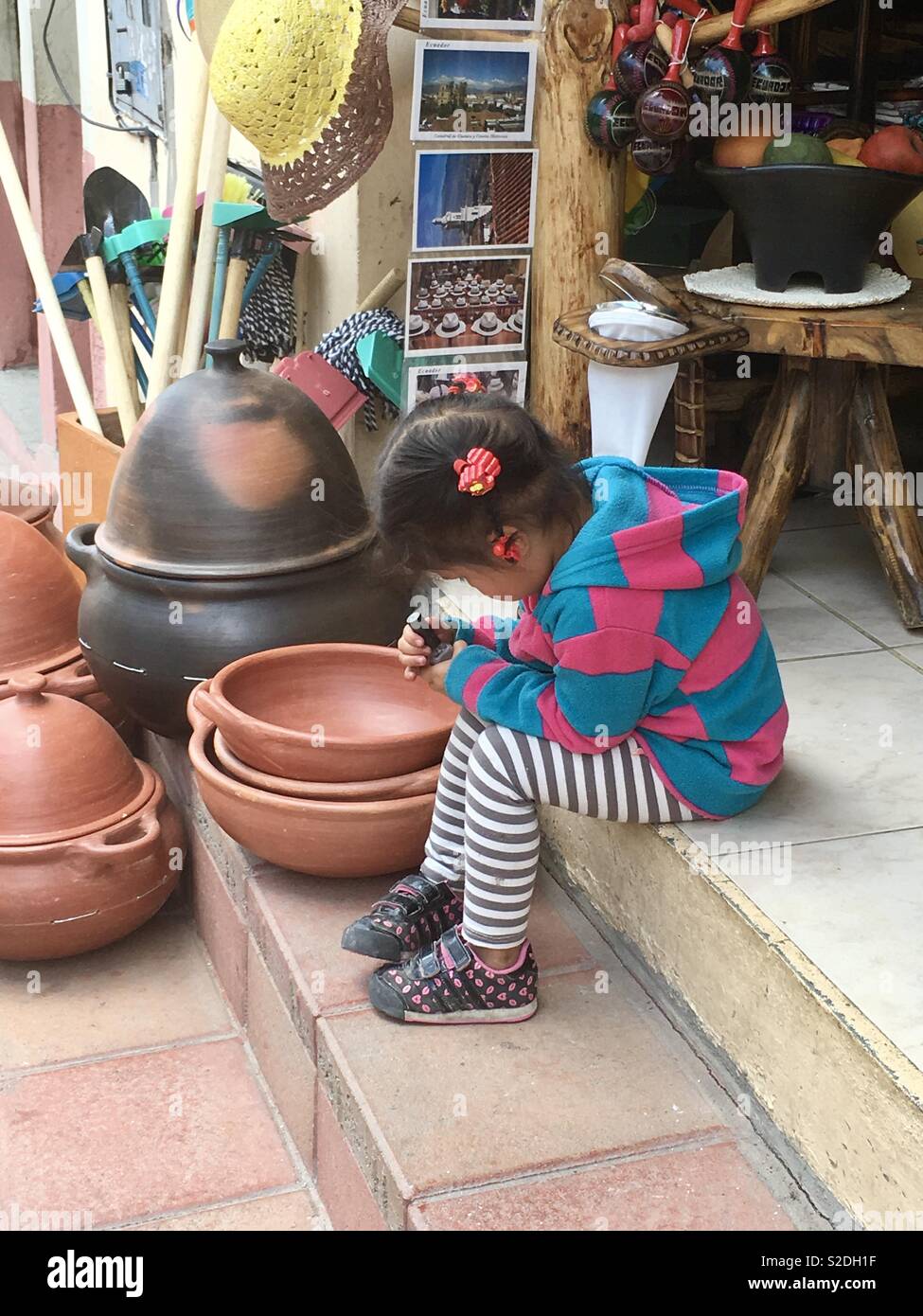 Ecuadorean girl outside of family’s pottery shop Stock Photo