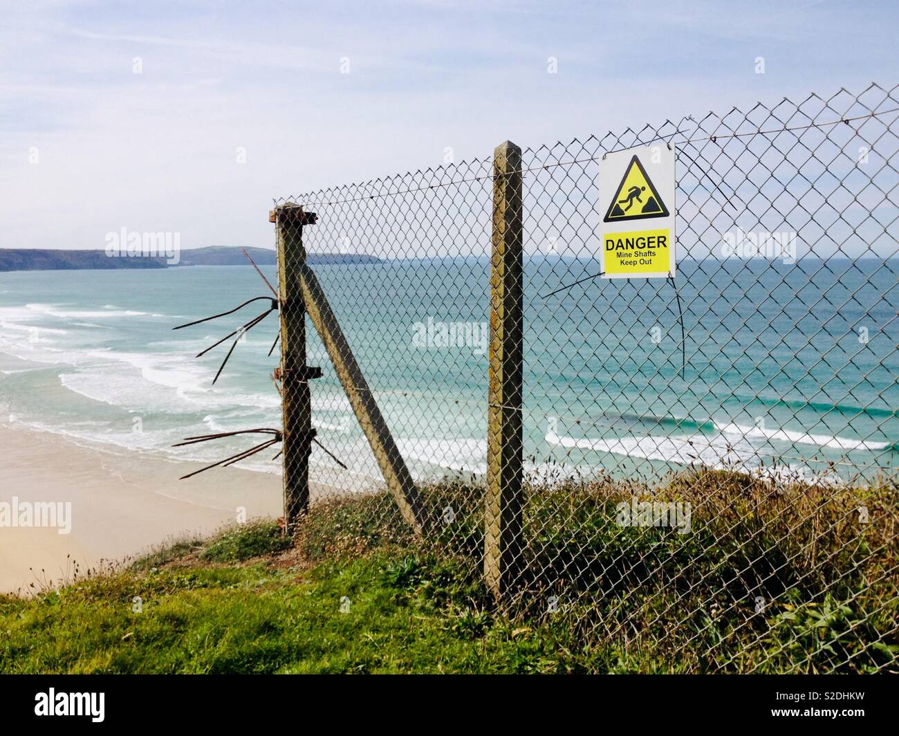 Danger mine shaft sign, keep out, on the south west coastal path, between Holywell and Perran sands. Perranporth beach seen in background Stock Photo