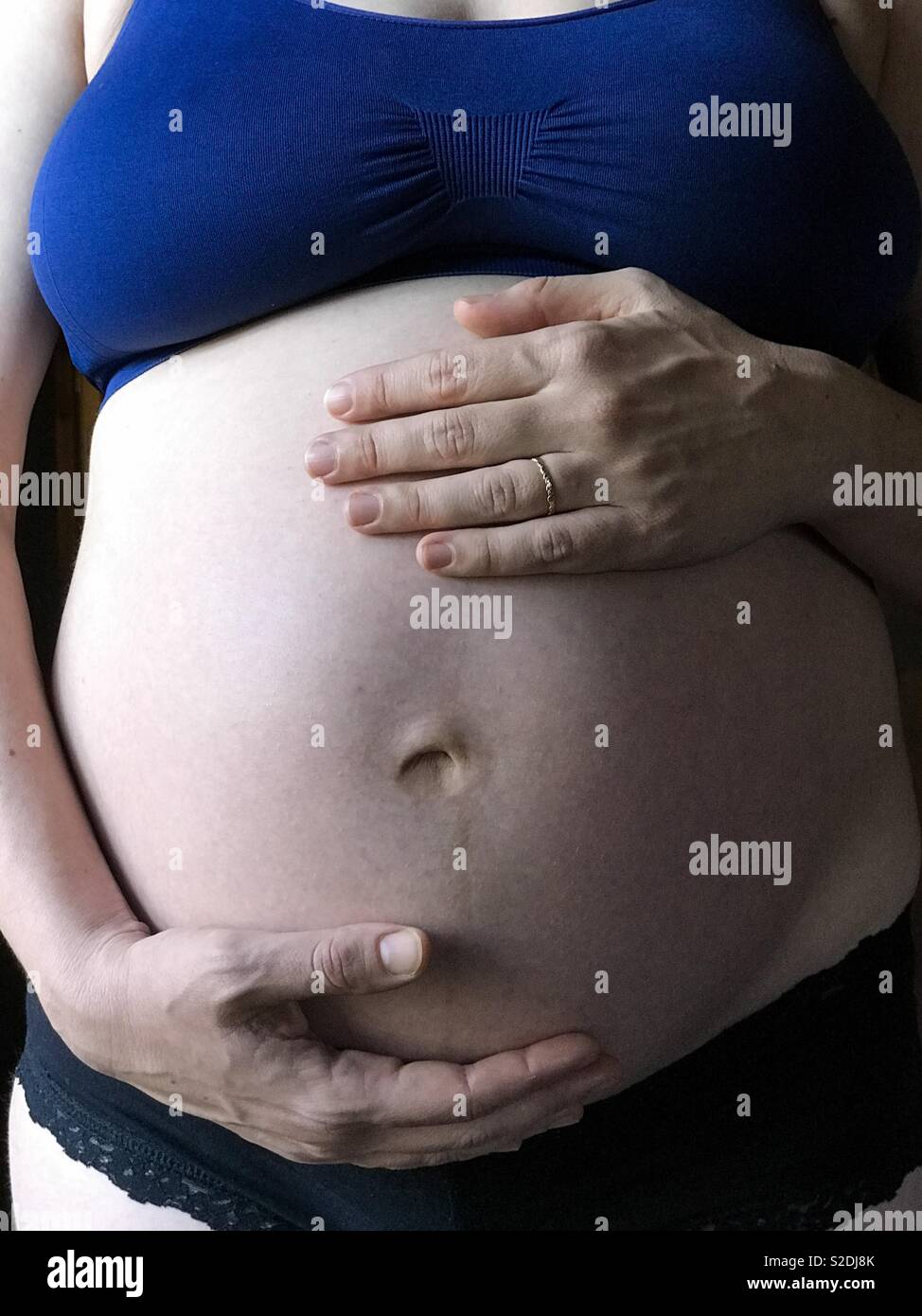 Close-up of a pregnant woman caressing her belly. Stock Photo