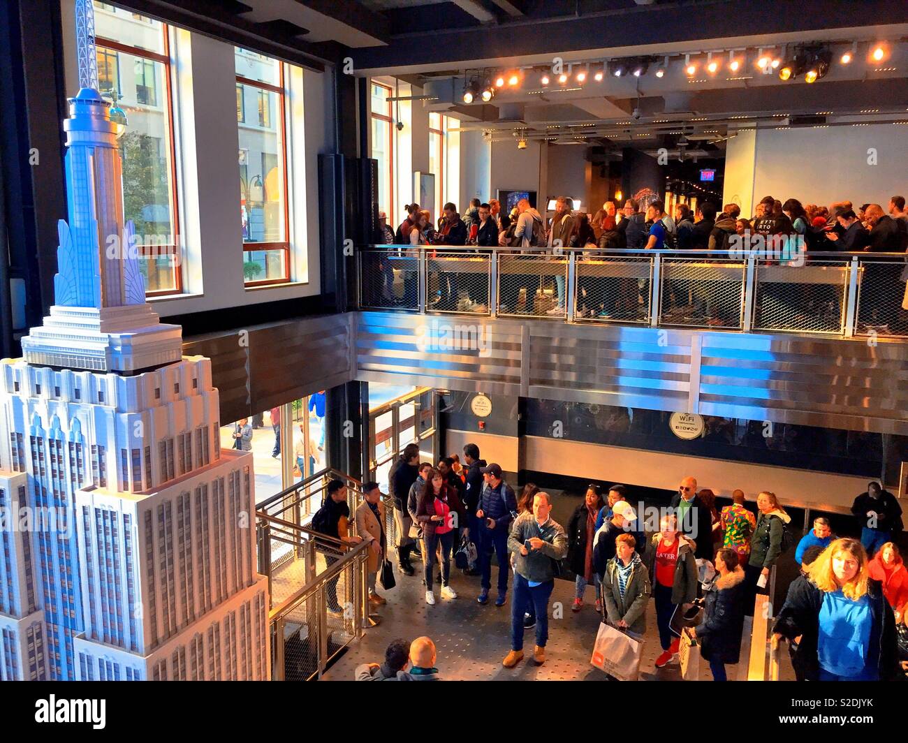 Crowds of people in the newly opened lobby of the Empire State building with large scale model of the building - Smartphone Captured Stock Image