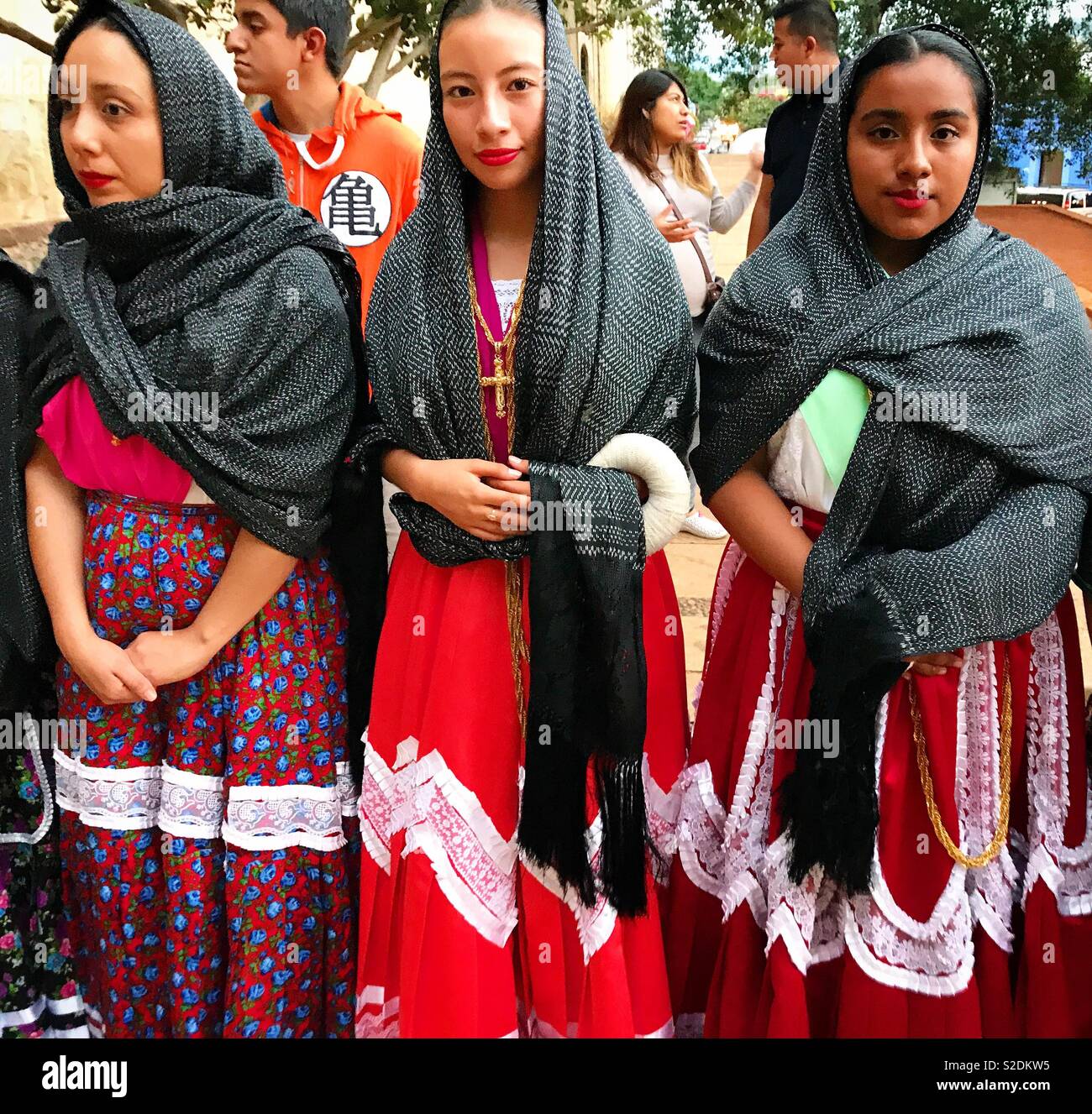 Women wear rebozos and traditional dresses during a religious celebration in the Templo de Santo Domingo church in Oaxaca, Mexico - Smartphone Captured Stock Image