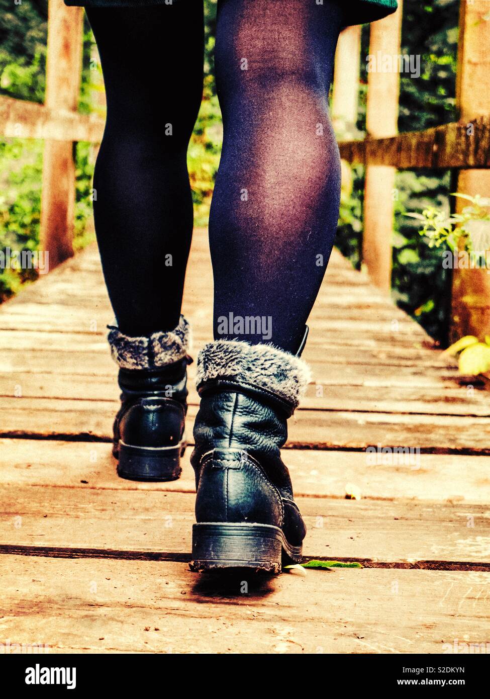Woman walking across a wooden bridge - Smartphone Captured Stock Image