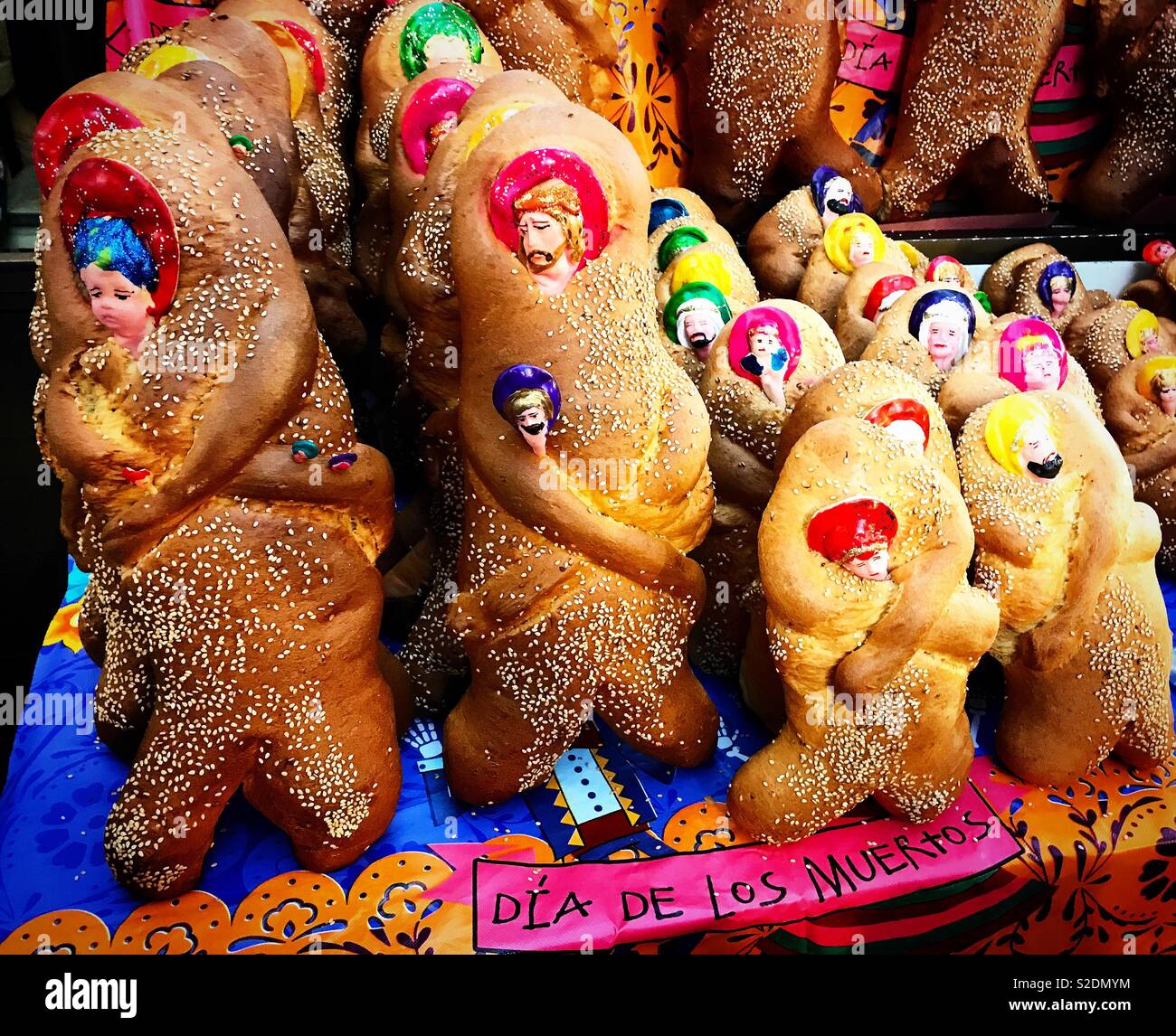 ‘Bread of the dead’, ‘pan de muerto’ in Spanish, decorated with faces of Jesus and saints, for sale in a market during Day of the Dead celebration in Oaxaca, Mexico Stock Photo