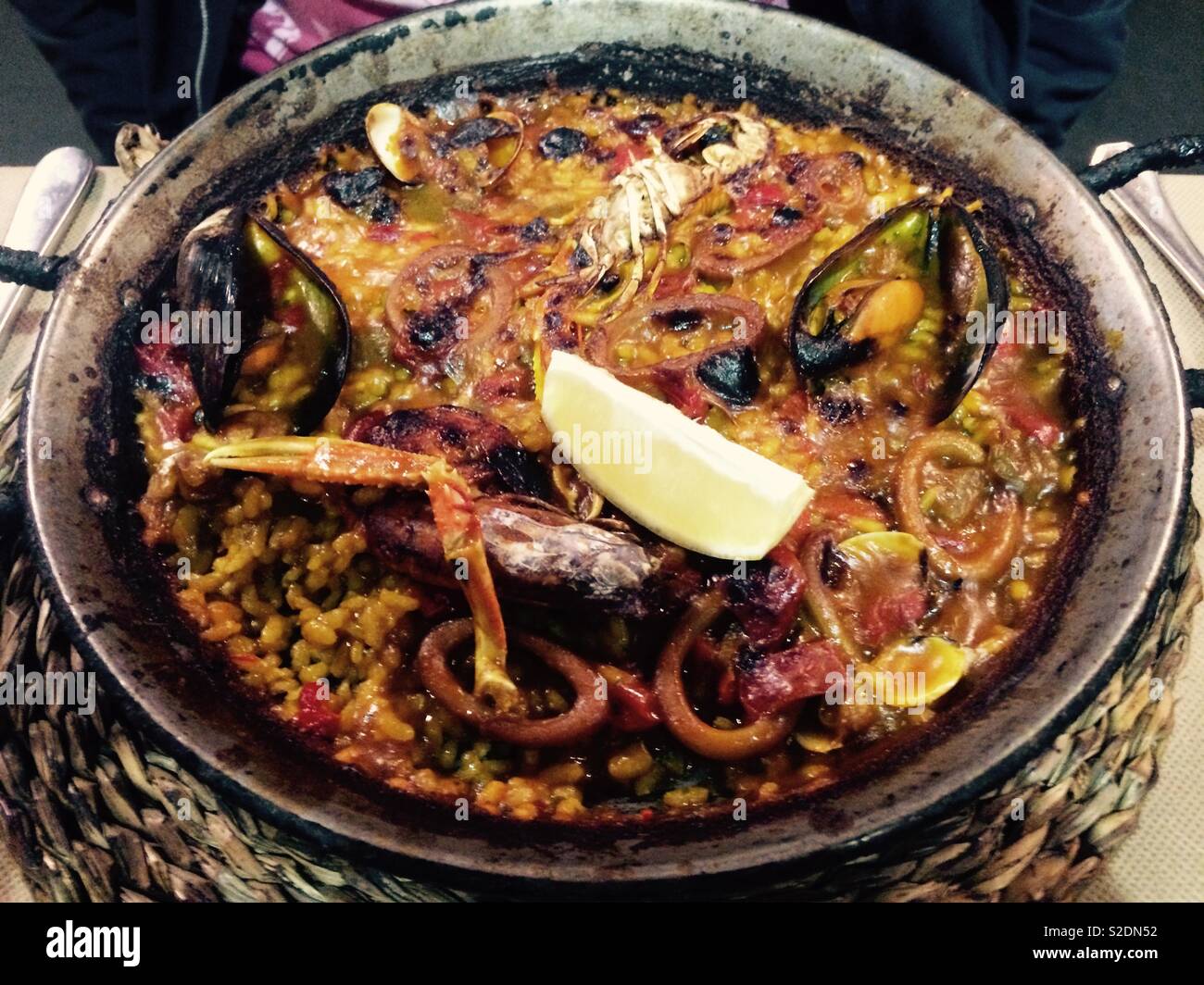Seafood paella served in authentic paella pan in restaurant in Barcelona Spain Stock Photo