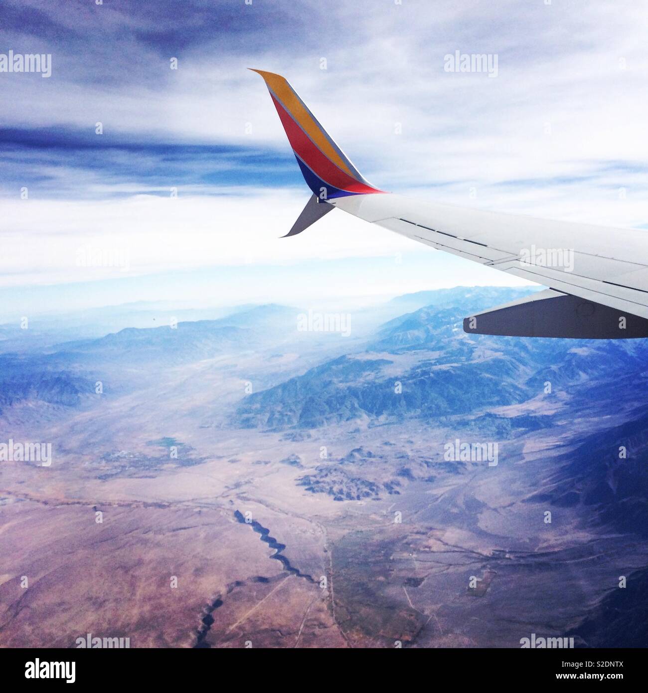Southwest Air wing seen while flying over desert landscape in the Western United States - Smartphone Captured Stock Image