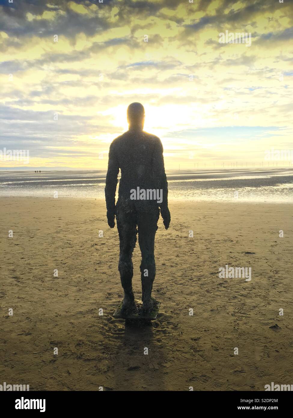 One of the iron statues created by Antony Gorley. Part of the installation “Another Place”, on Crosby Beach, Merseyside. - Smartphone Captured Stock Image