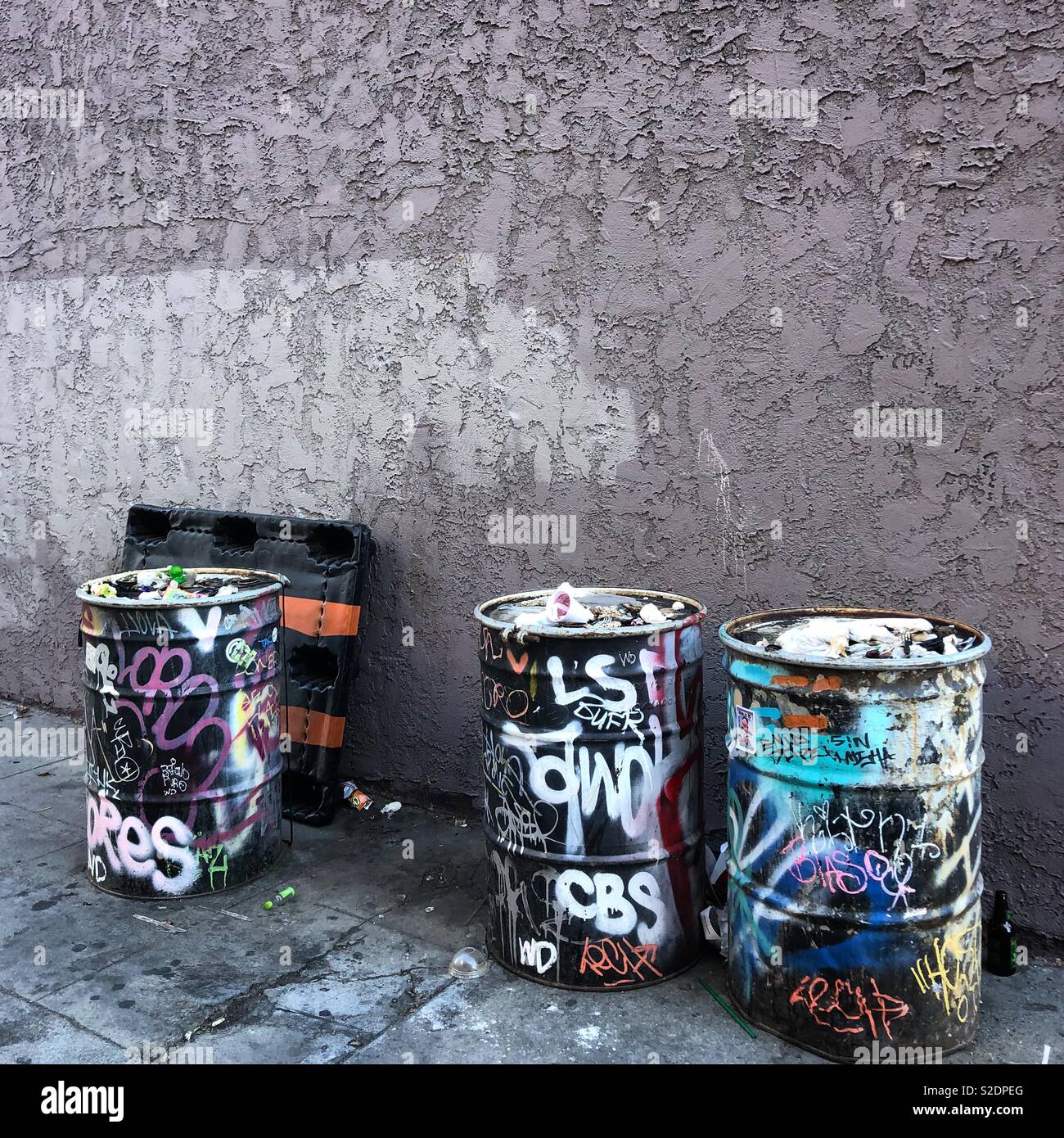 https://c8.alamy.com/comp/S2DPEG/graffiti-covered-trash-cans-against-a-wall-in-an-alley-S2DPEG.jpg