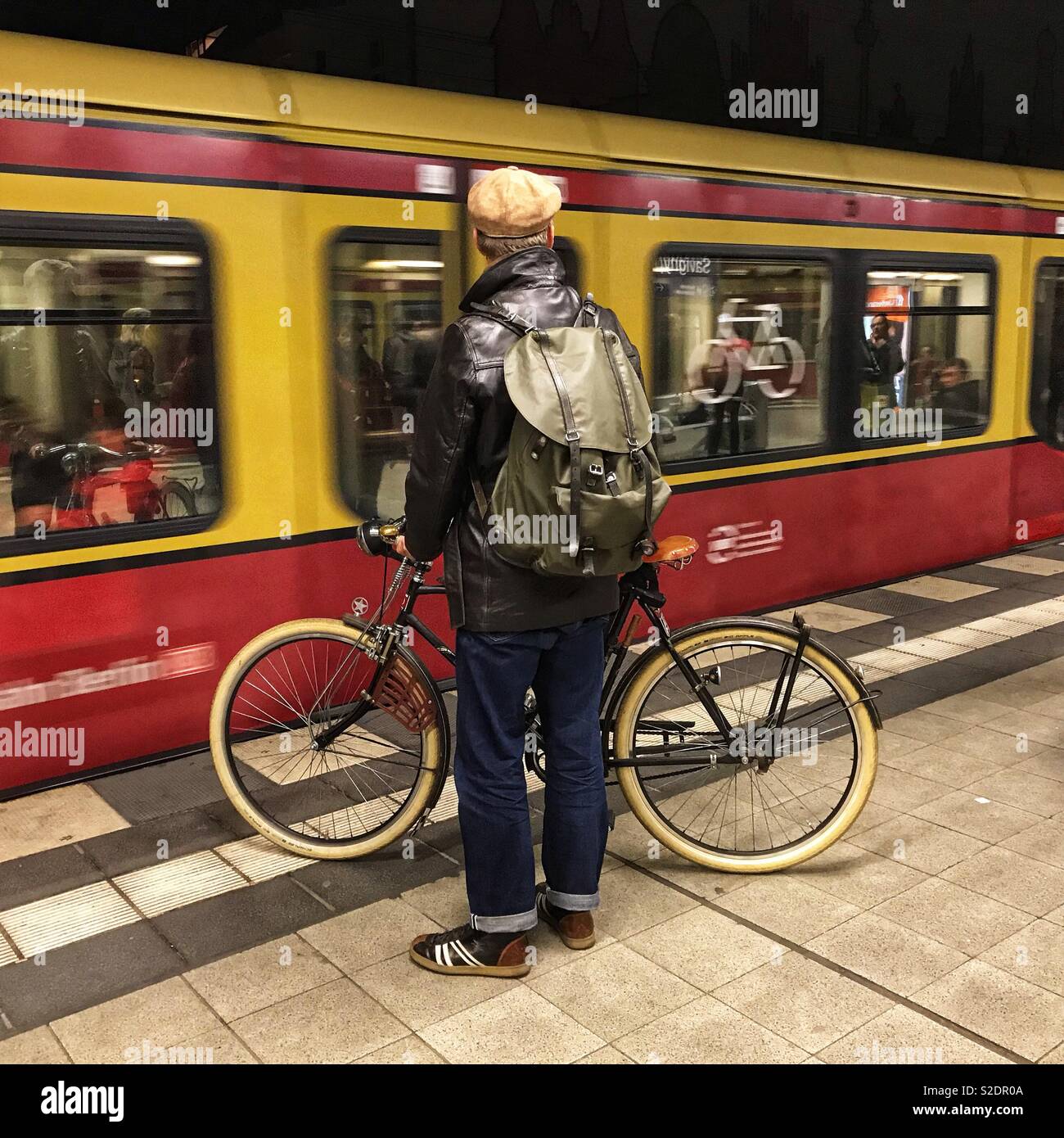 Berlin Germany a passenger takes his bicycle onto the S-Bahn city train service. The carriages have sections for bikes. - Smartphone Captured Stock Image